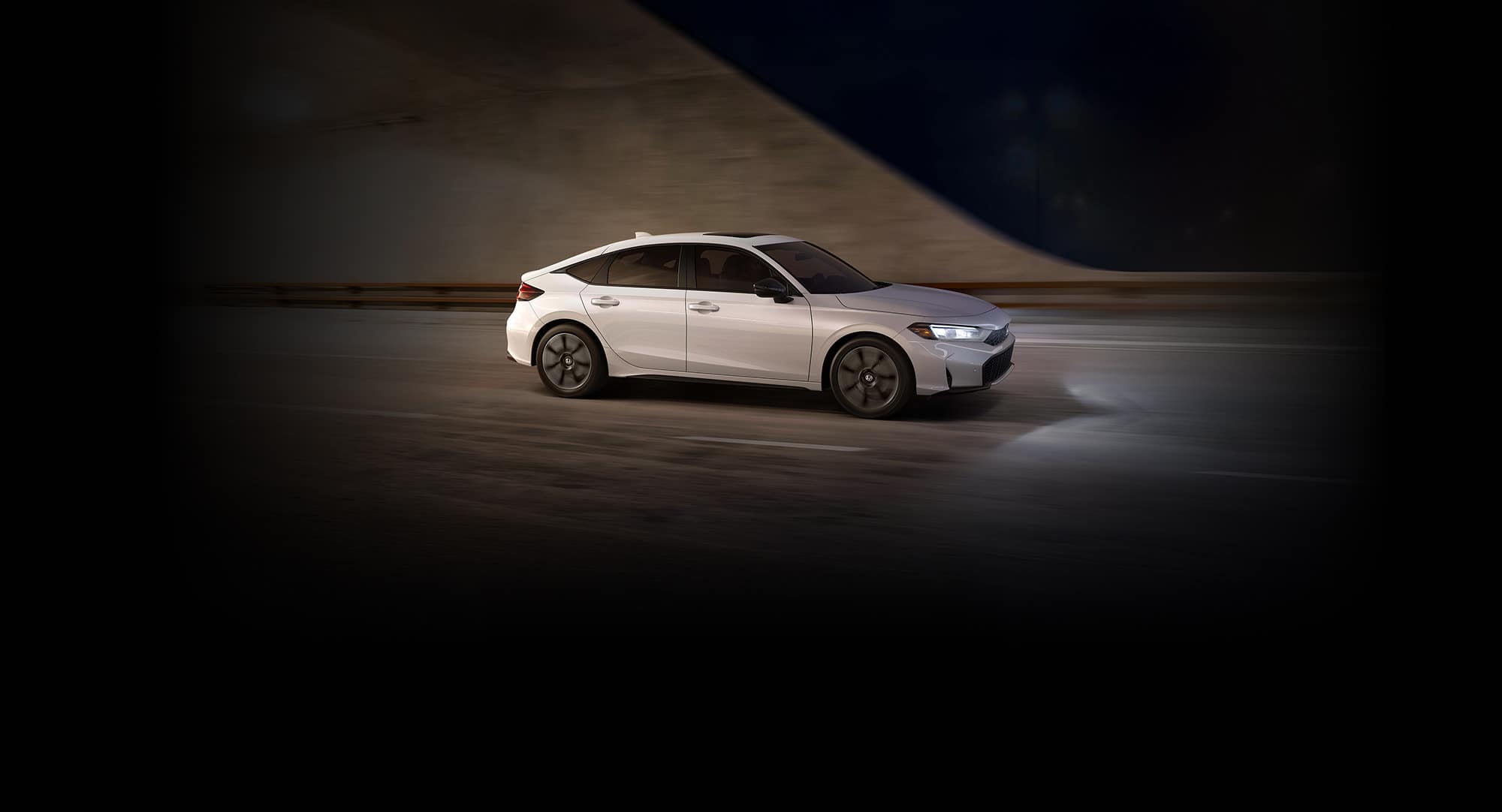 2027 Honda Civic Hatchback Touring Hybrid in Platinum White Pearl profile driving through a tunnel (Compact Hatchback).
